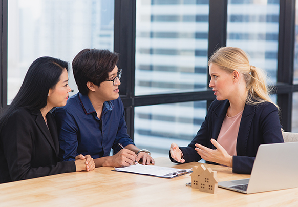 A couple talking to their agent at a table