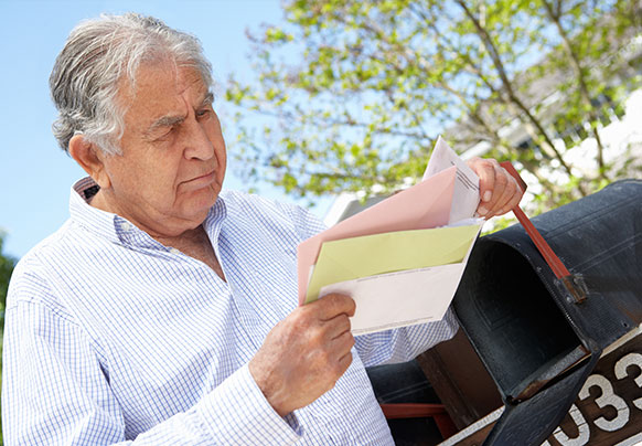 Man reading mail by mailbox